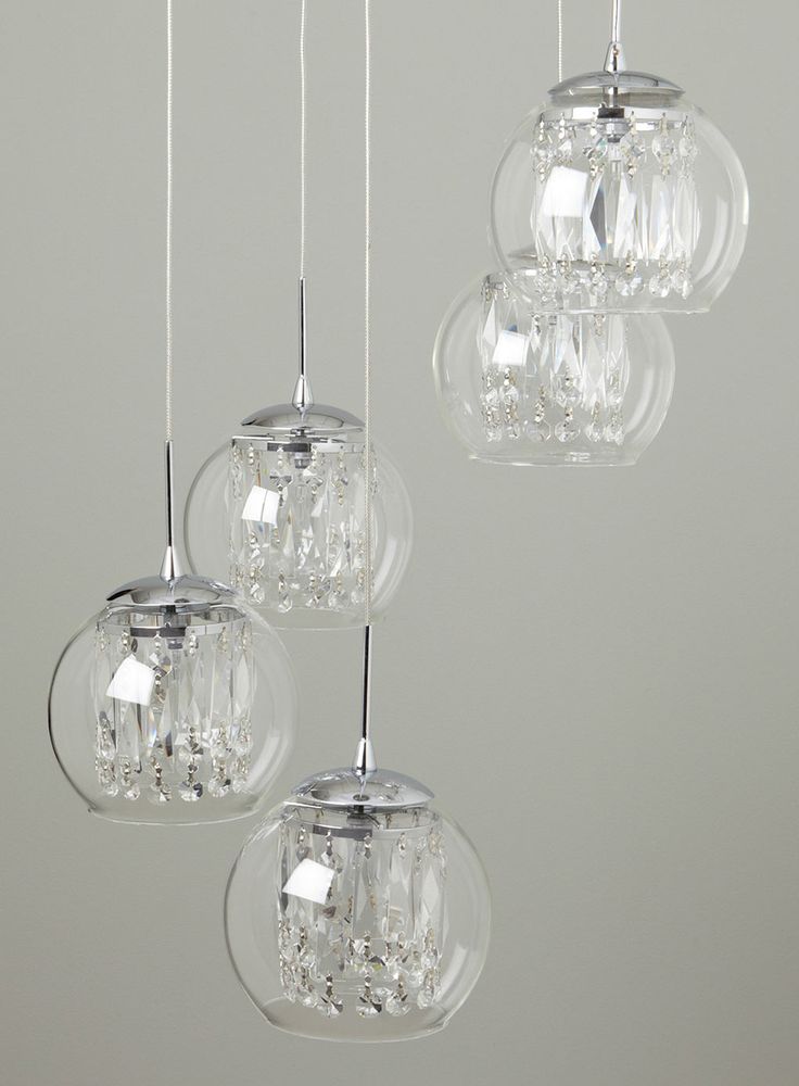 three clear glass globes hanging from a ceiling fixture with crystal balls on the bottom