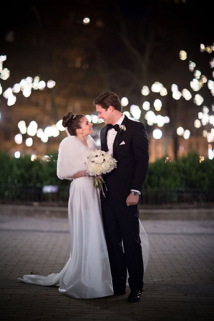 a bride and groom standing in front of fireworks