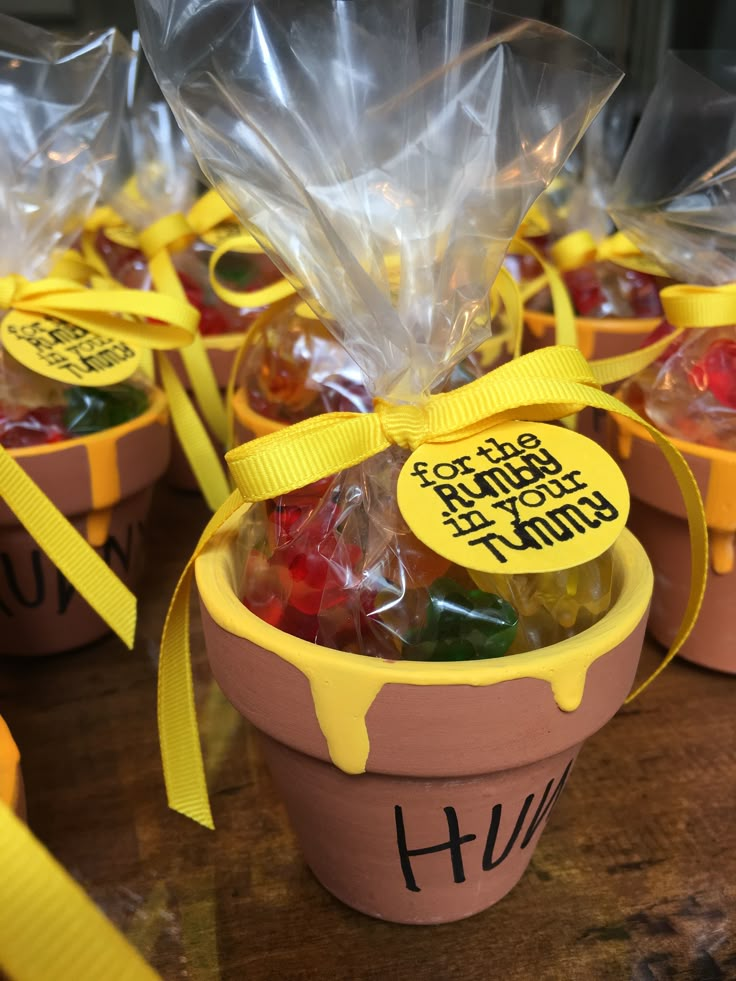 small plastic buckets filled with candies and wrapped in cellophane, sitting on a table