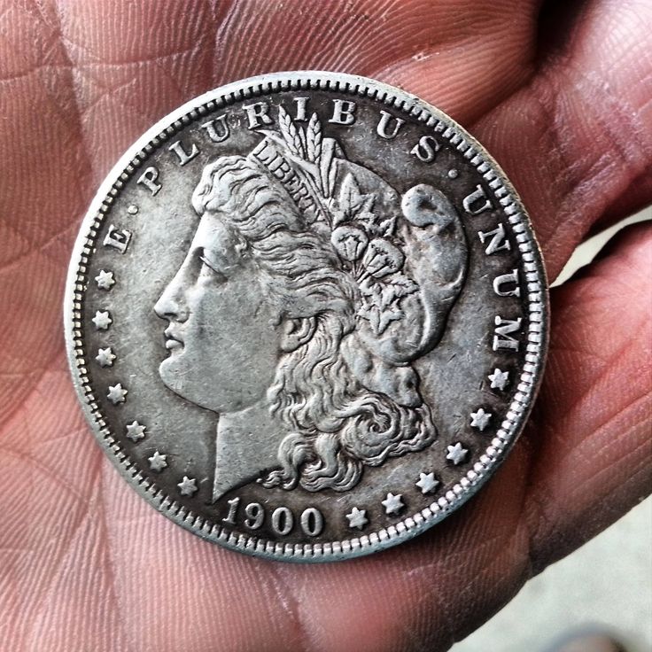 an old silver coin is being held in someone's hand and it looks like they are