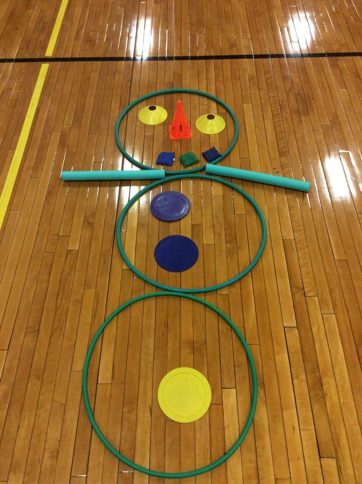 a wooden floor with circles and markers on it in the middle of an indoor gym