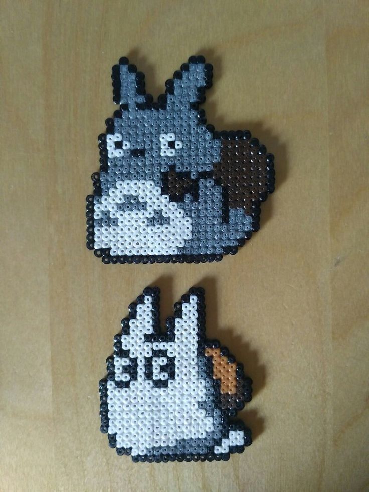 two pieces of bead art on a wooden surface