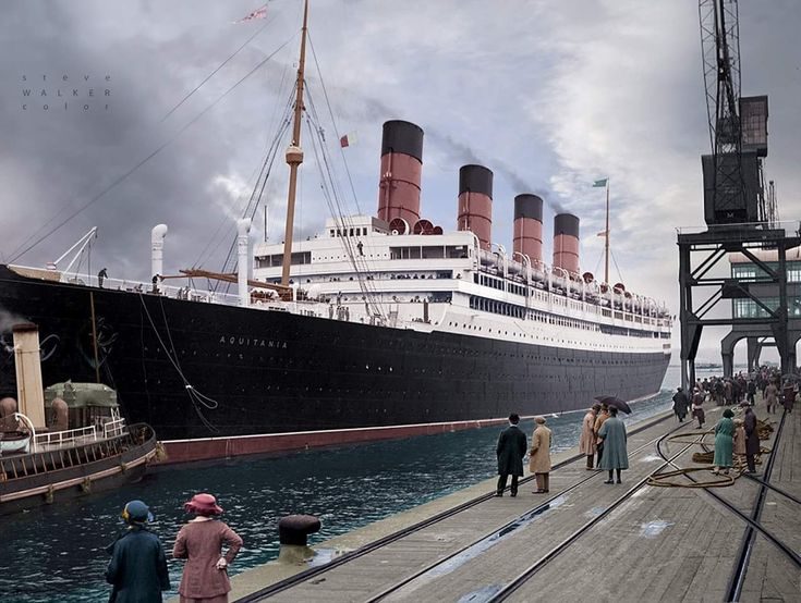 people are standing on the dock in front of a large ship