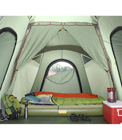 the inside of a tent with an open door and sleeping bag in front of it