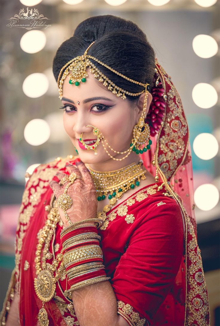 a woman in red and gold outfit with jewelry on her head, posing for the camera