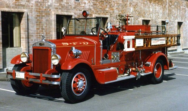 an old fire truck is parked on the street