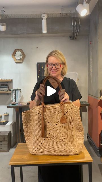 a woman is holding a woven bag in her hands