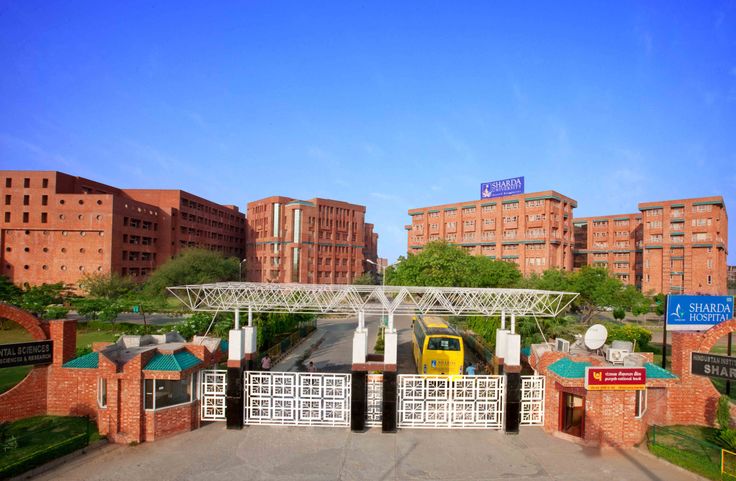 a yellow car is parked at the entrance to a brick building in front of some tall buildings