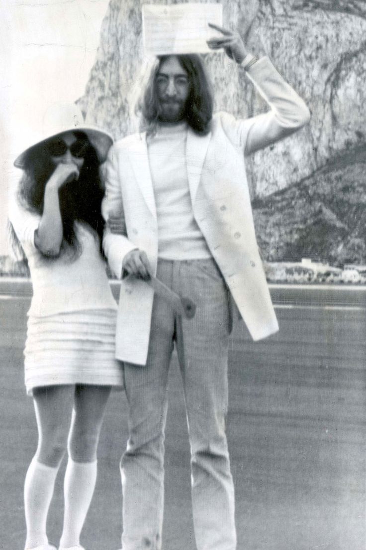 a man and woman are standing in front of a mountain