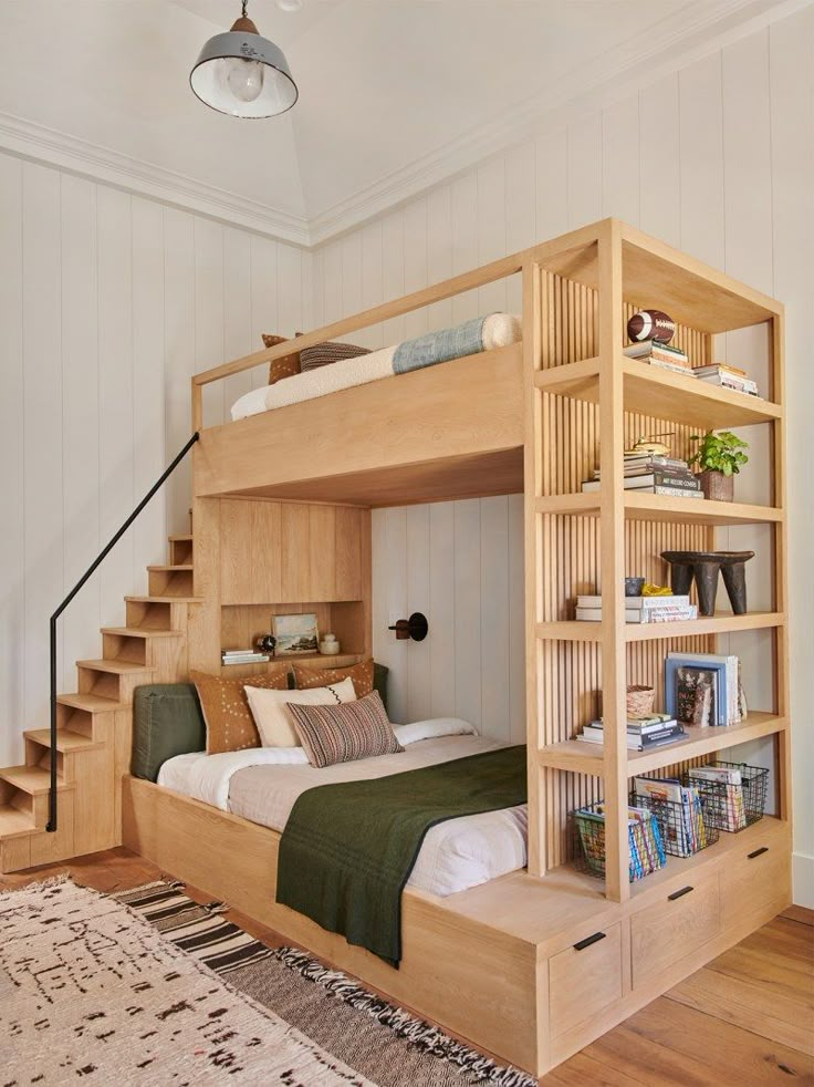 there is a bunk bed in the room with stairs and bookshelves on it