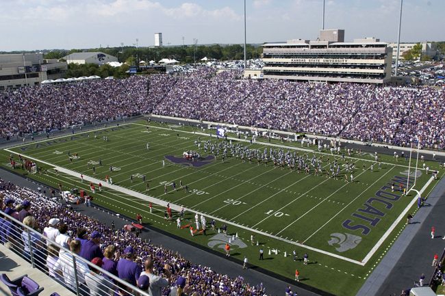 a football stadium filled with lots of purple and white people watching the game from the bleachers