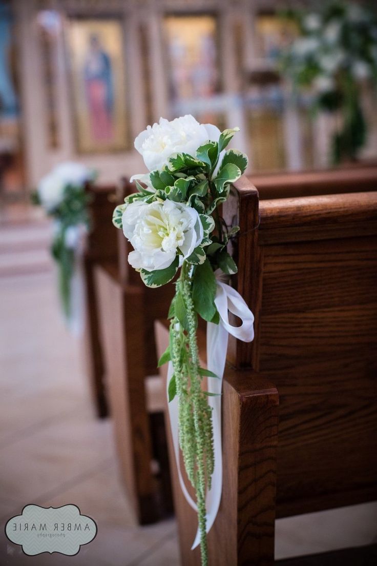 a bouquet of flowers sitting on the pews of a church