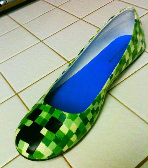 a pair of green and black checkered shoes sitting on top of a tiled floor