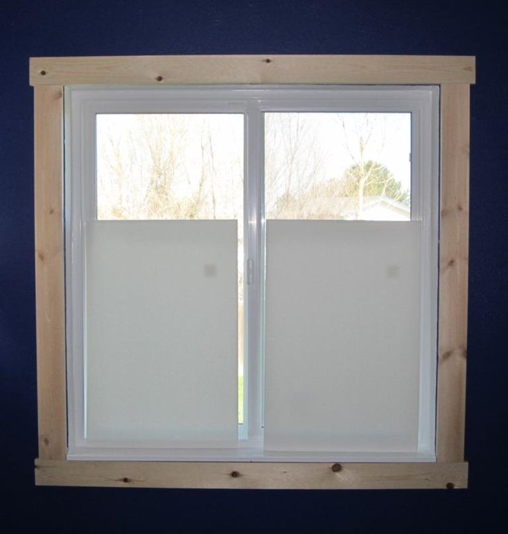 an open window in a room with blue walls and white blinds on the windowsill