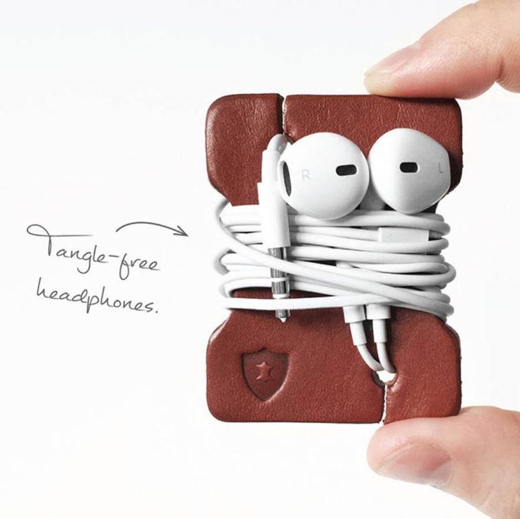 a hand holding an ipod case with earbuds attached to it