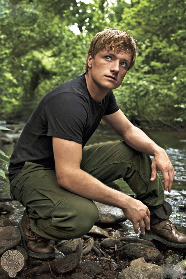 a man squatting on rocks next to a river