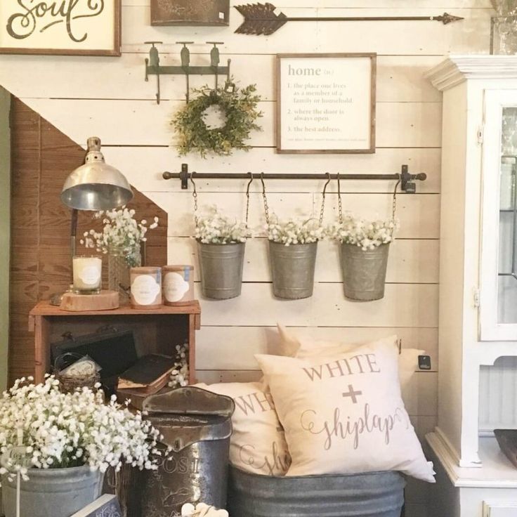 a living room filled with potted plants next to a stair case full of flowers