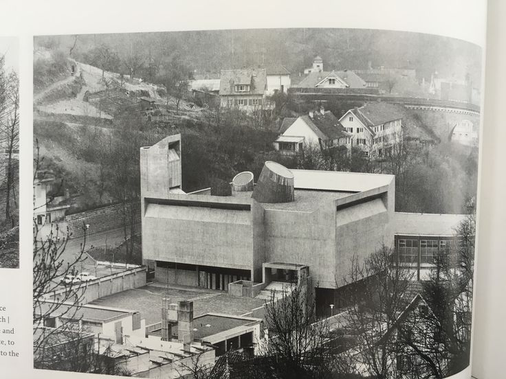 an old black and white photo of a building in the middle of trees with buildings around it