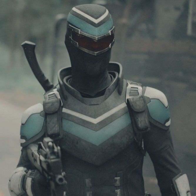 a man in a sci - fi suit and helmet walking down the street with two swords