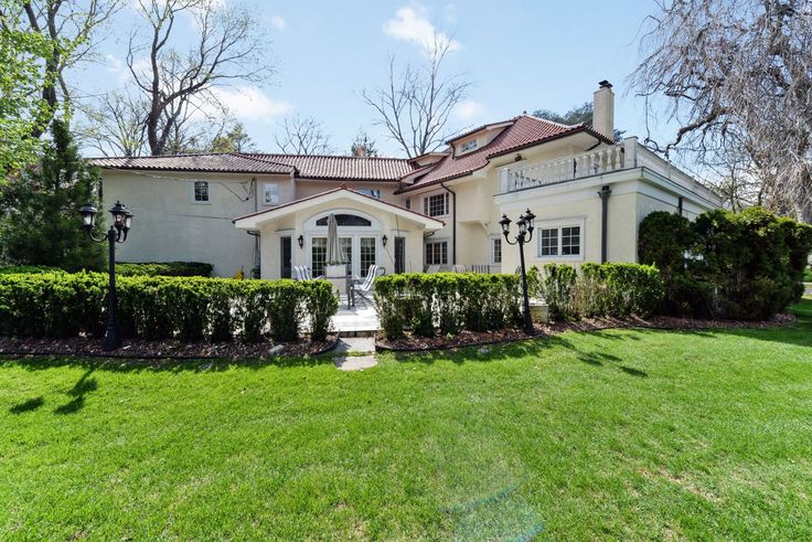 a large white house sitting on top of a lush green field