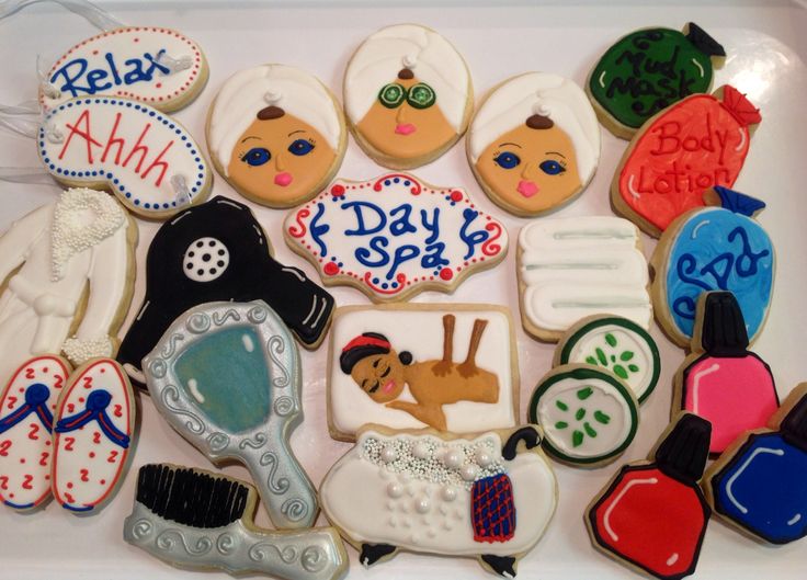 some decorated cookies in the shape of women's day spas and grooms