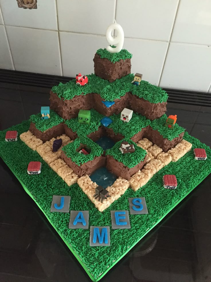 a cake made to look like a maze on top of green grass with letters and animals