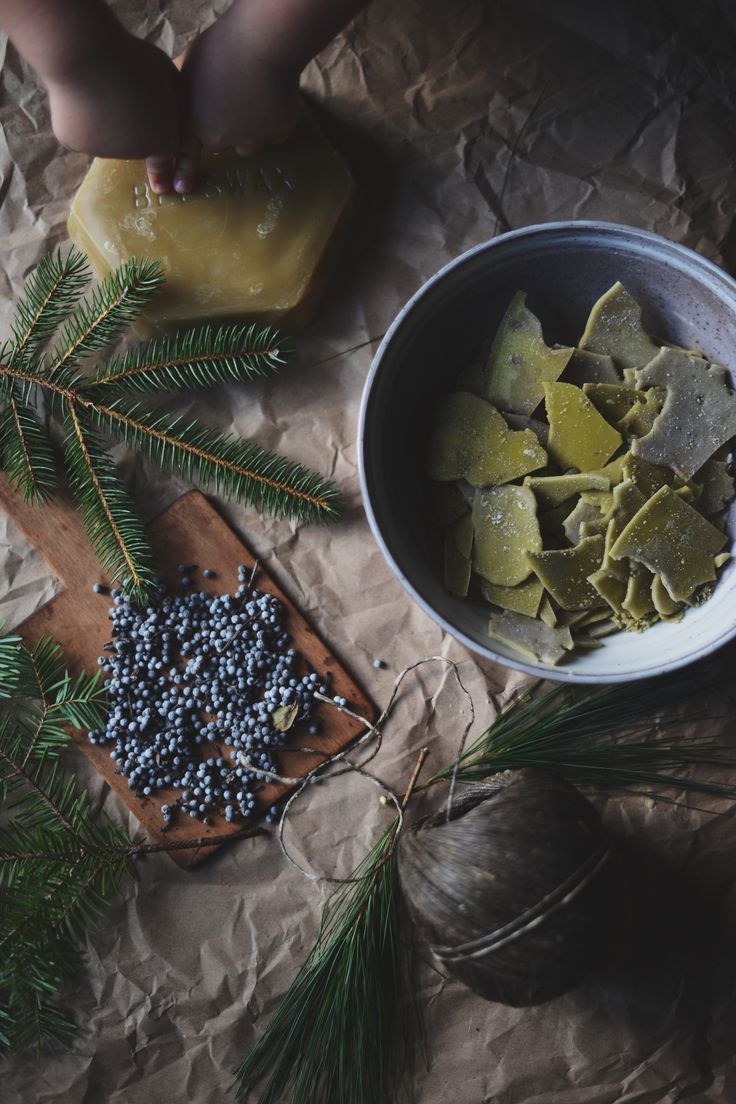 some food is sitting in a bowl next to pine branches and other things on the table