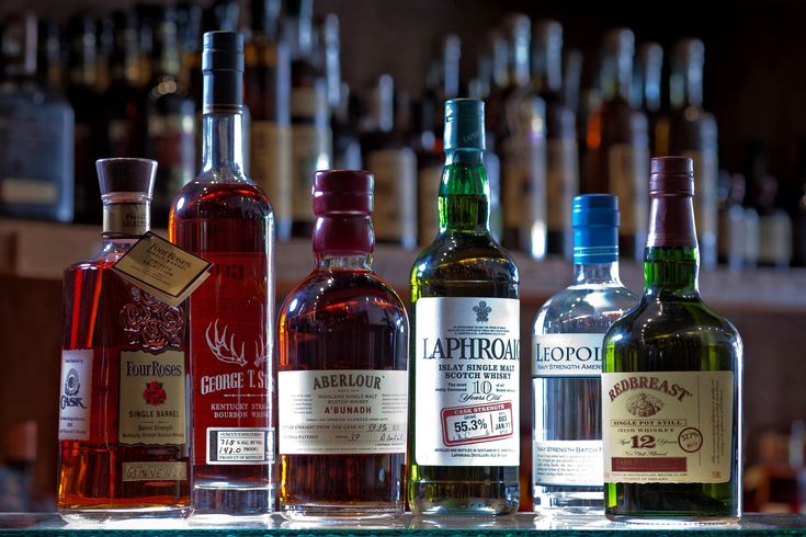 several bottles of alcohol lined up on a bar