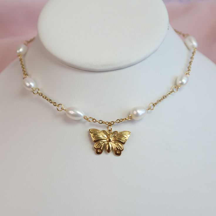 The Flutter Pearl Choker features a delicate butterfly pendant, crafted from high-quality stainless steel with a gold finish and accented with shimmering AAA pearls. The choker is fully adjustable for a comfortable fit on any neck size. Hypoallergenic and gentle on sensitive skin, it combines quality materials with a unique design for those who value both style and comfort. * Stainless Steel * Skin-friendly * AAA 8mm freshwater pearls * Waterproof * Pendant- 13mm x 22mm * Adjustable  * Lobster c Gold Metal Butterfly Necklace, Dainty Adjustable Gold Butterfly Necklace, Gold Adjustable Butterfly Necklace With Clavicle Chain, Butterfly Choker Necklace With Clavicle Chain For Gift, Adjustable Gold Butterfly Necklace With Clavicle Chain, Monarch Butterfly Aesthetic, Wedding Butterfly, Butterfly Aesthetic, Necklace Fairy