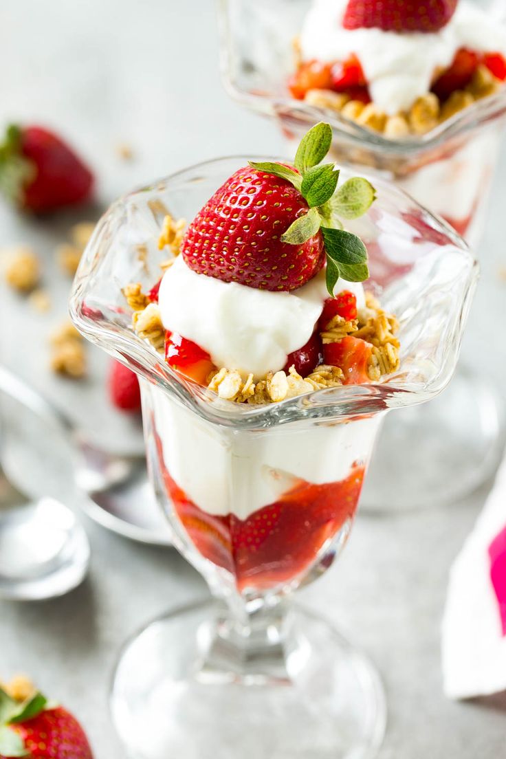 strawberry parfaits in a glass dish with yogurt and strawberries on top