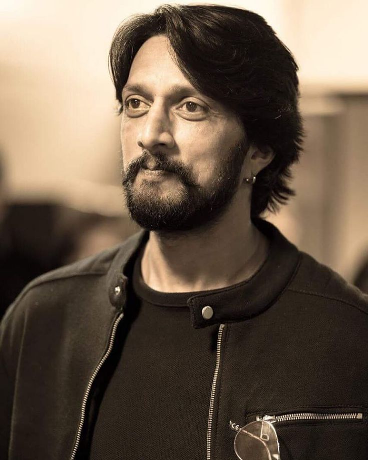 a black and white photo of a man with long hair, wearing a leather jacket