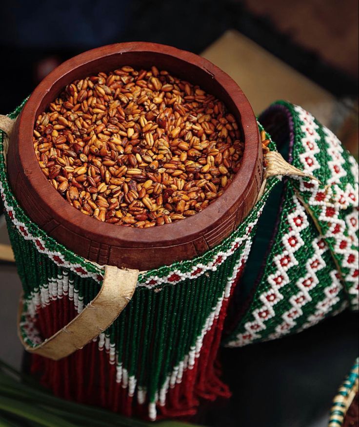 a wooden bowl filled with nuts on top of a table