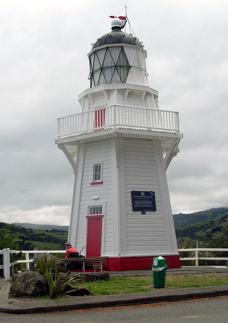 a white and red light house sitting on the side of a road