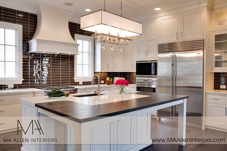 a large kitchen with white cabinets and an island in the middle is decorated with pink flowers