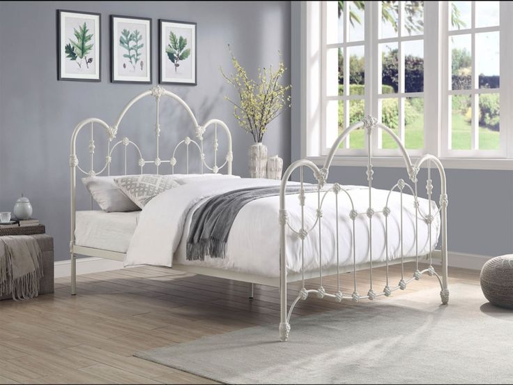 a white metal bed frame in a bedroom