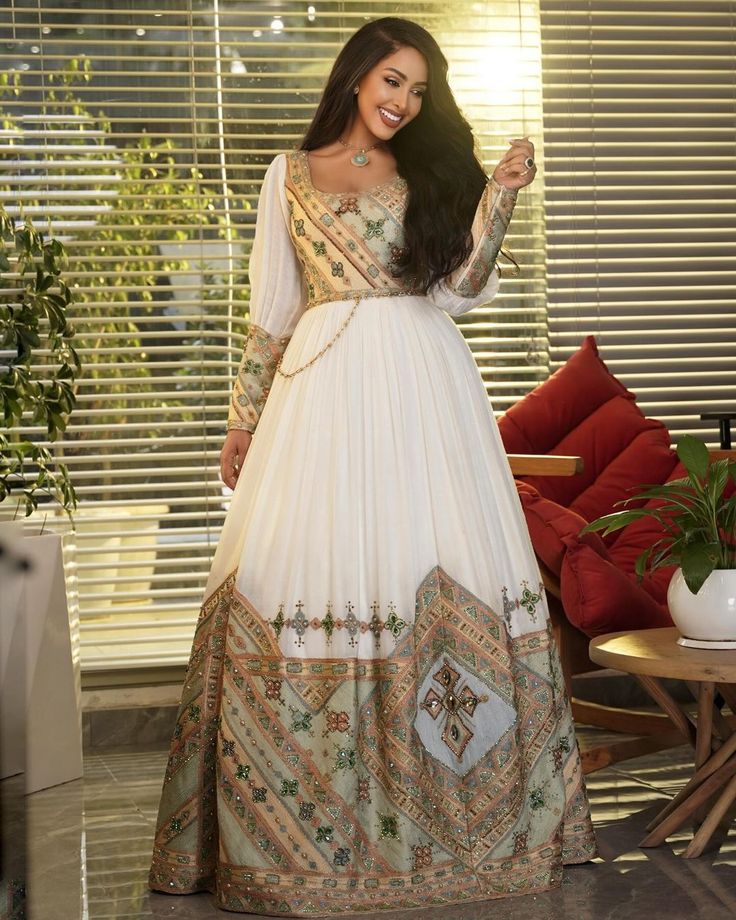 Indulge in the timeless beauty of this modern Ethiopian Habesha wedding dress, adorned with exquisite hand beadwork. Its intricate embroidery and delicate craftsmanship create a captivating and luxurious look. Perfect for your special day, this dress is a testament to the artistry of Ethiopian artisans and will make you feel like a true queen. Material Cotton Thread Menen Estimated delivery : 4 weeks to 6 weeks Contact WhatsApp +1(304)-306-2784Email: contact@ethiopian.store Ethiopian Bridal Dress, Eritrean Wedding Dress, Floor-length Gown With Cutdana For Traditional Ceremonies, White Gown For Traditional Ceremonies, Traditional Semi-stitched Embellished Gown, Traditional Floor-length Wedding Dress, White Anarkali Gown With Cutdana, White Gown For Transitional Season Traditional Ceremonies, Embellished Gown For Wedding Eid Festival