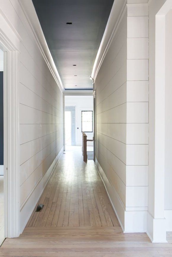 an empty hallway with wood floors and white walls