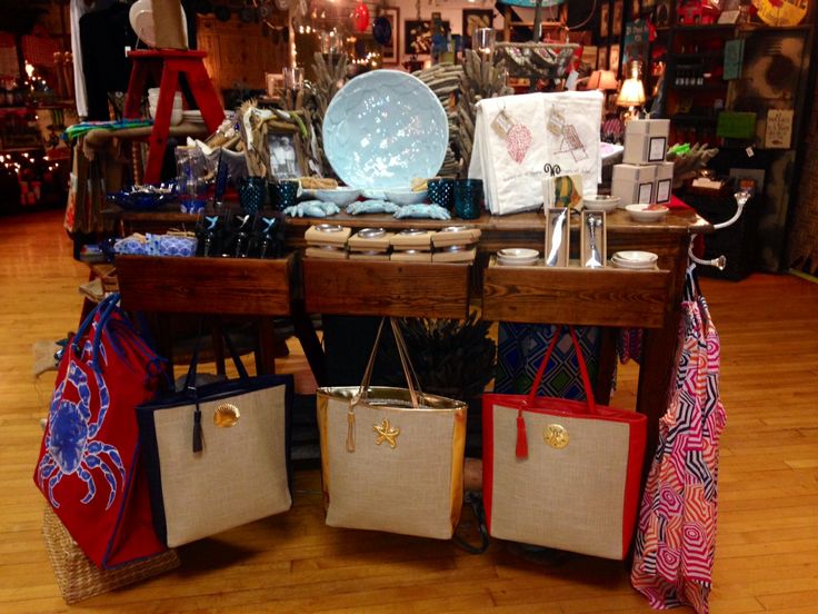 several bags and purses are on display in a room with wood flooring,