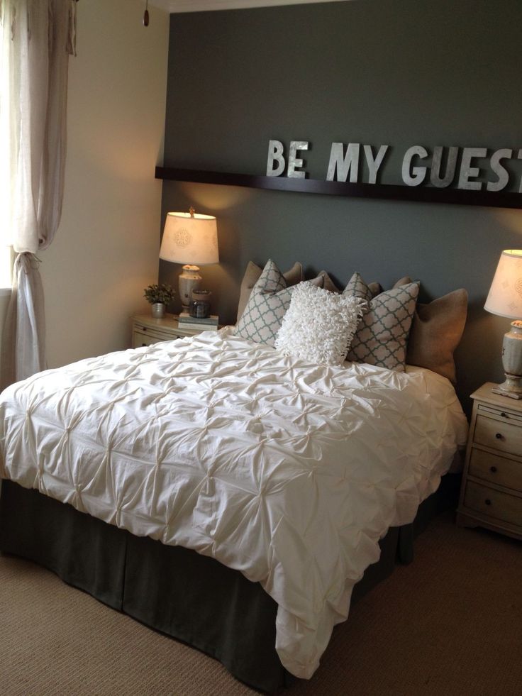 a bed sitting in a bedroom next to two lamps on either side of the bed