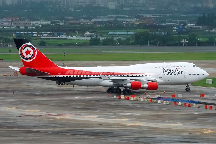 a large jetliner sitting on top of an airport tarmac with buildings in the background