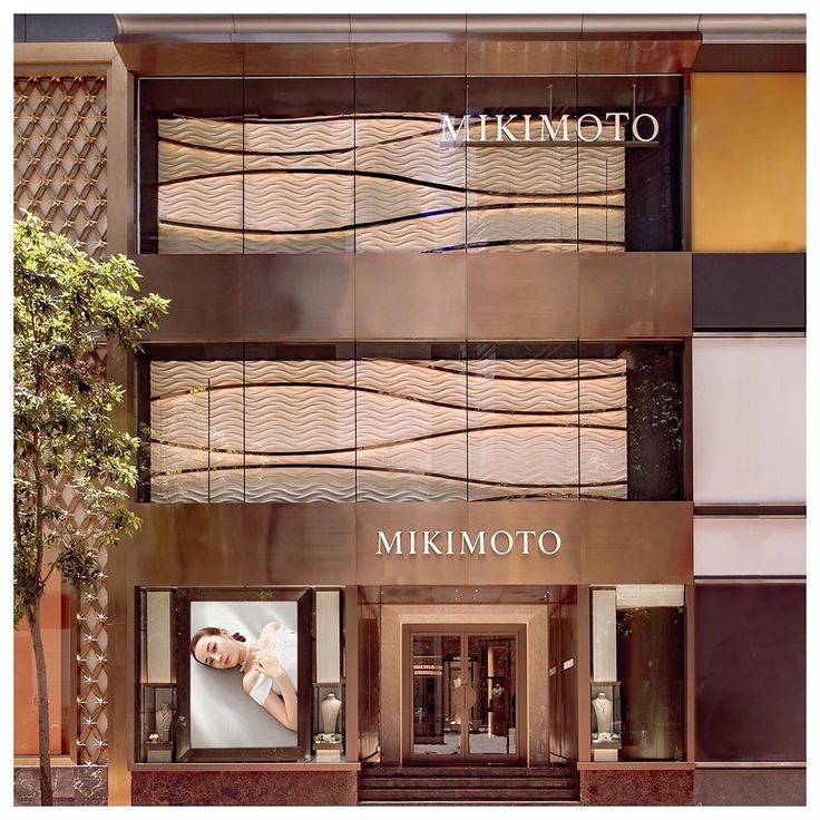 an advertisement for the mikimoto store in front of a building