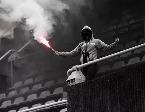 a man in a hoodie holding a red and black fire extinguisher