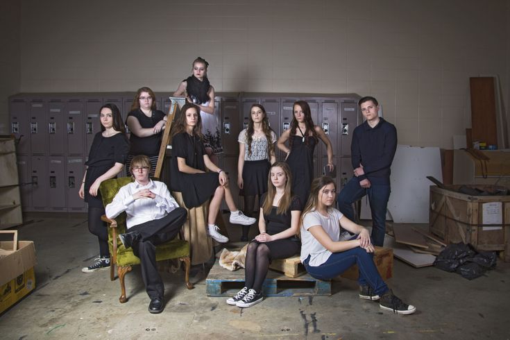 a group of people posing for a photo in a room with lockers and boxes