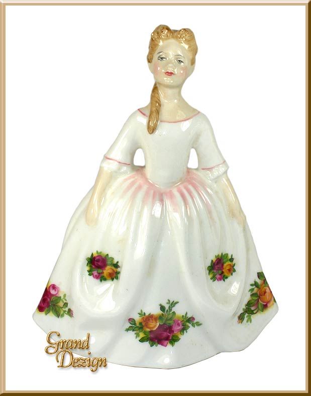 a ceramic figurine of a woman wearing a white dress with flowers on it