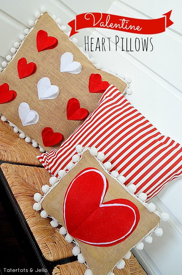 valentine's day pillows with hearts on them and pom poms around the edges