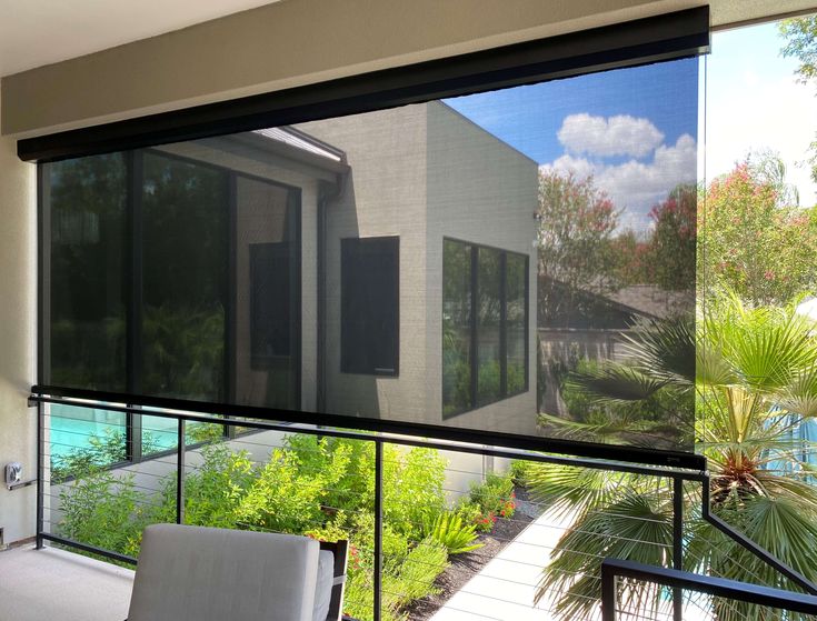 a large window with blinds on it in front of a house and pool outside the windows