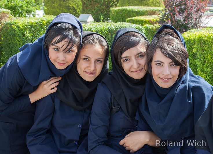 four girls in blue dresses are posing for the camera with their arms around each other