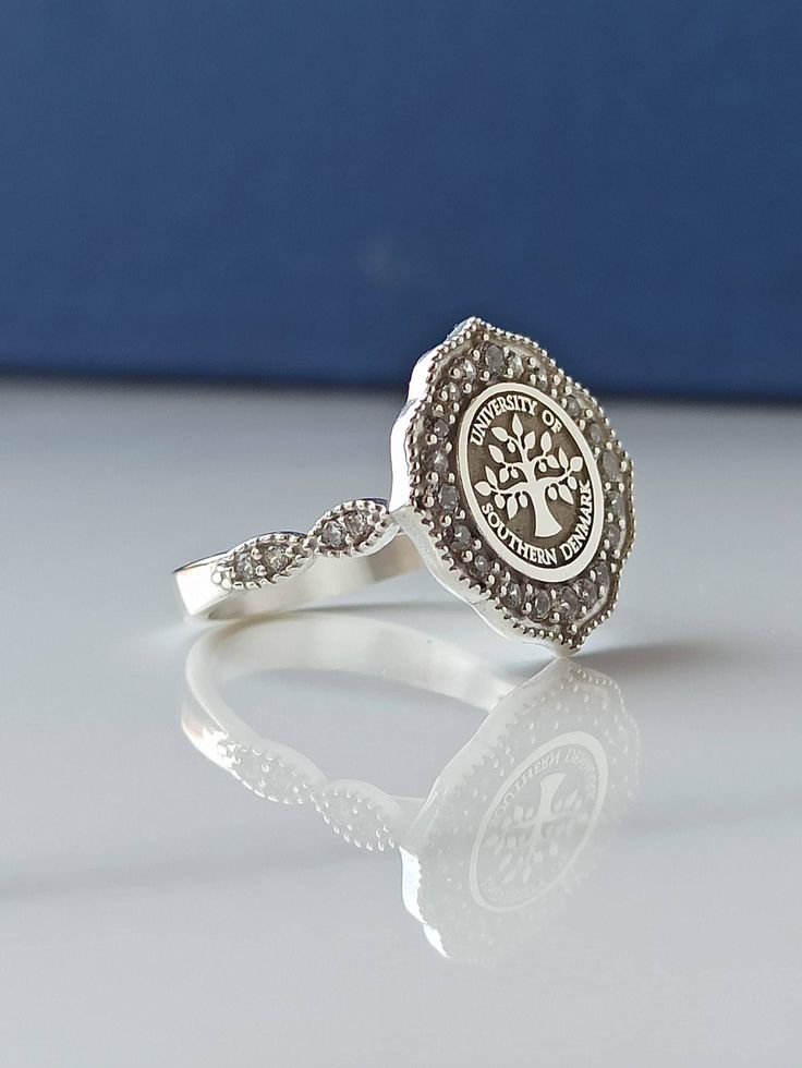 This product is GUARANTEED for life. * College graduation rings for men and women delicately engraved with your school logo or any other initials or image you want. * The ring has solid back. Deep and detailed engraving very delicately handcrafted unisex - looks super cool on both women & men * The ring is 925 Silver * Please contact me for your 14 carat and 18 carat solid gold requests. I can gladly do. * Certified 14k solid gold, hallmarked 14k for solid gold rings. * The ring has solid ba Sterling Silver Spiritual Engraved Ring, Spiritual Sterling Silver Signet Ring For Gift, Spiritual Sterling Silver Engraved Ring, Spiritual Engraved Sterling Silver Ring, Spiritual Sterling Silver Rings With Engraving Option, Heirloom Sterling Silver Toe Ring, Sterling Silver Engraved Diamond Ring As Gift, Spiritual Sterling Silver Engraved Ring Gift, Symbolic Sterling Silver Rings For Anniversary