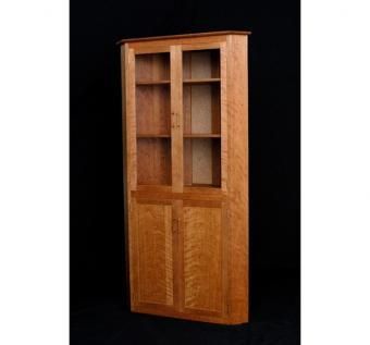 a wooden bookcase with glass doors on the front and bottom shelves, against a black background