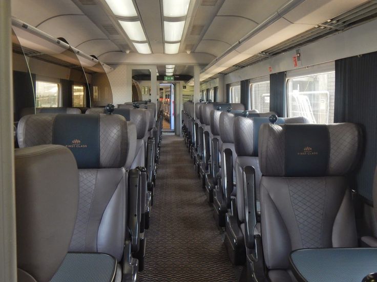 an empty train car with many seats and windows